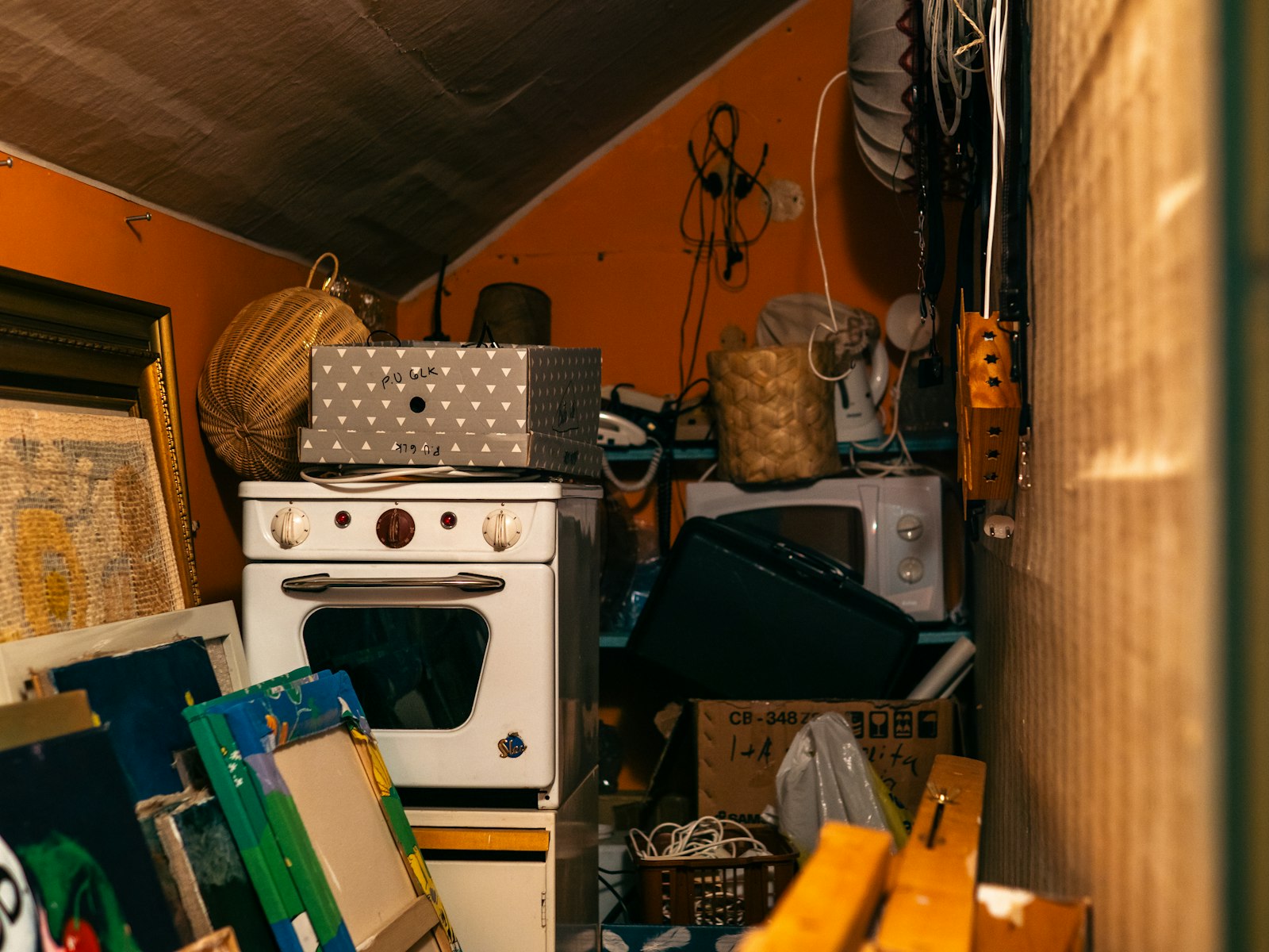 A storage room stuffed with boxes, an old stove and forgotten things